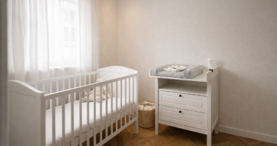 Детская комната в скандинавском стиле с белым пеленальным комодом SUNDVIK у стены, деревянная кроватка слева, мягкий серый пеленальный коврик сверху