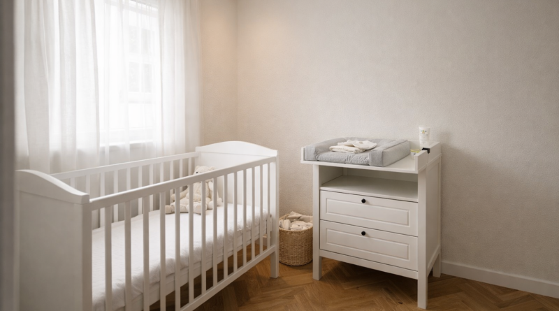 Детская комната в скандинавском стиле с белым пеленальным комодом SUNDVIK у стены, деревянная кроватка слева, мягкий серый пеленальный коврик сверху