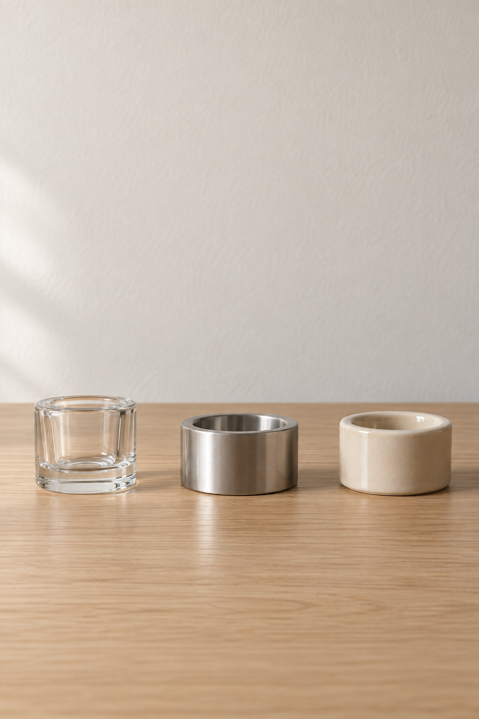 Три подсвечника IKEA в ряд: FINSMAK из прозрачного стекла, PRAKTAND из стали, VINDSTILLA из бежевой керамики
