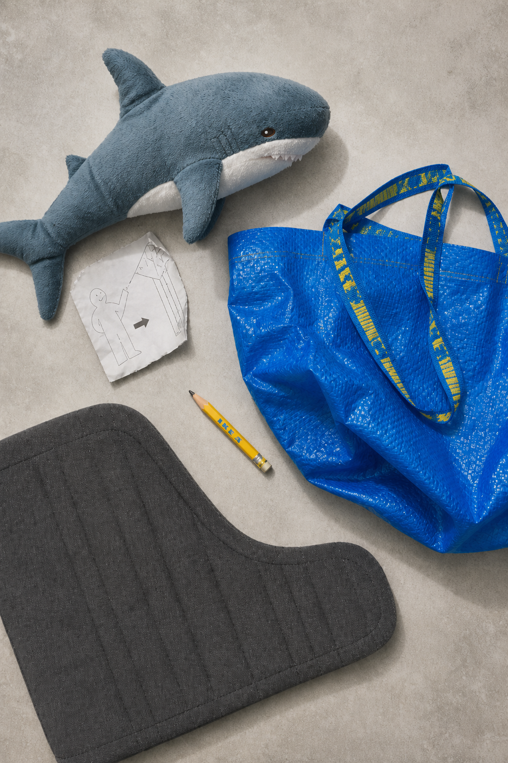 Иконы IKEA: мягкая игрушка акула BLÅHAJ, синяя сумка FRAKTA, подушка кресла POÄNG в flat-lay