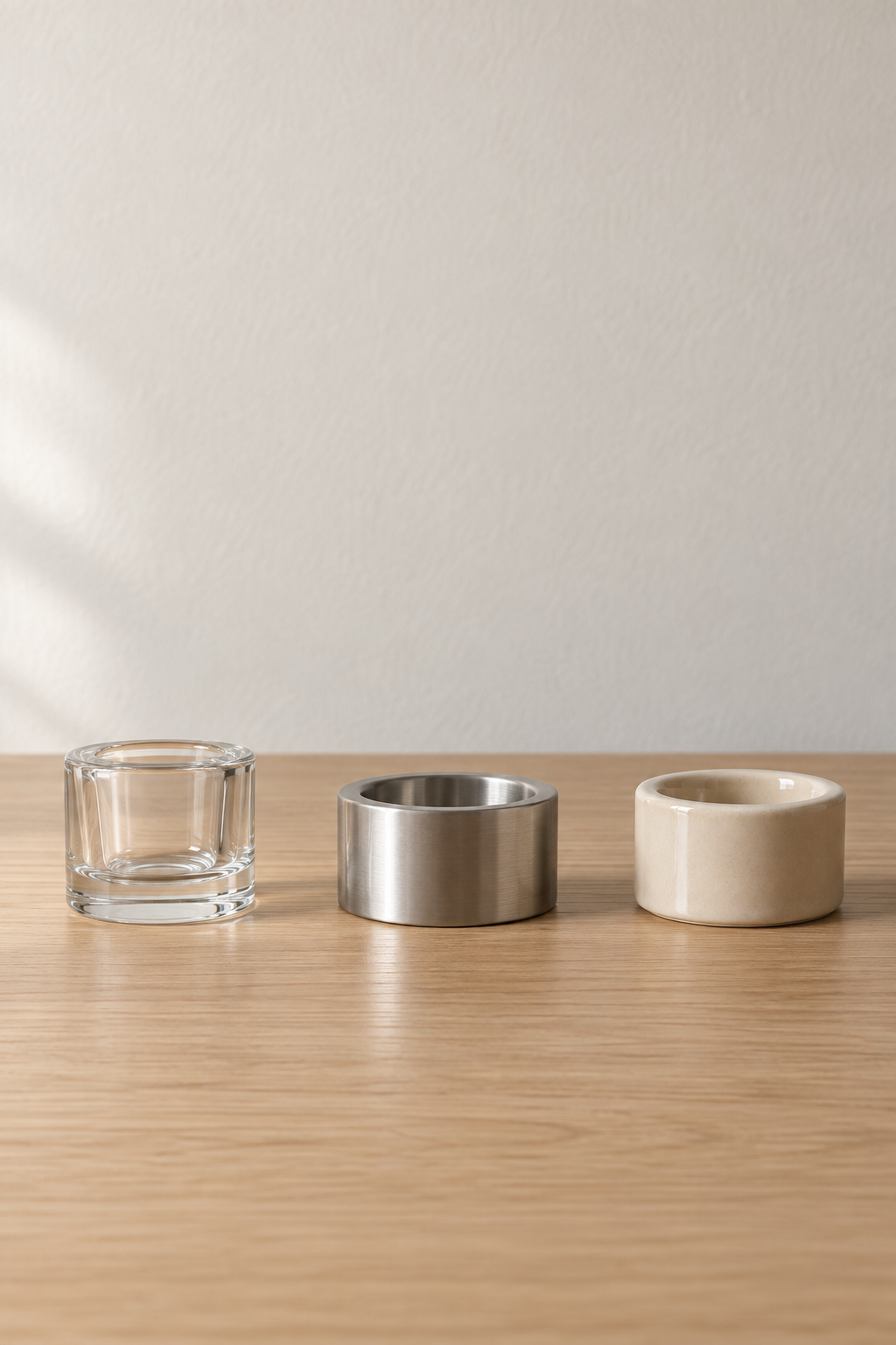Три подсвечника IKEA в ряд: FINSMAK из прозрачного стекла, PRAKTAND из стали, VINDSTILLA из бежевой керамики