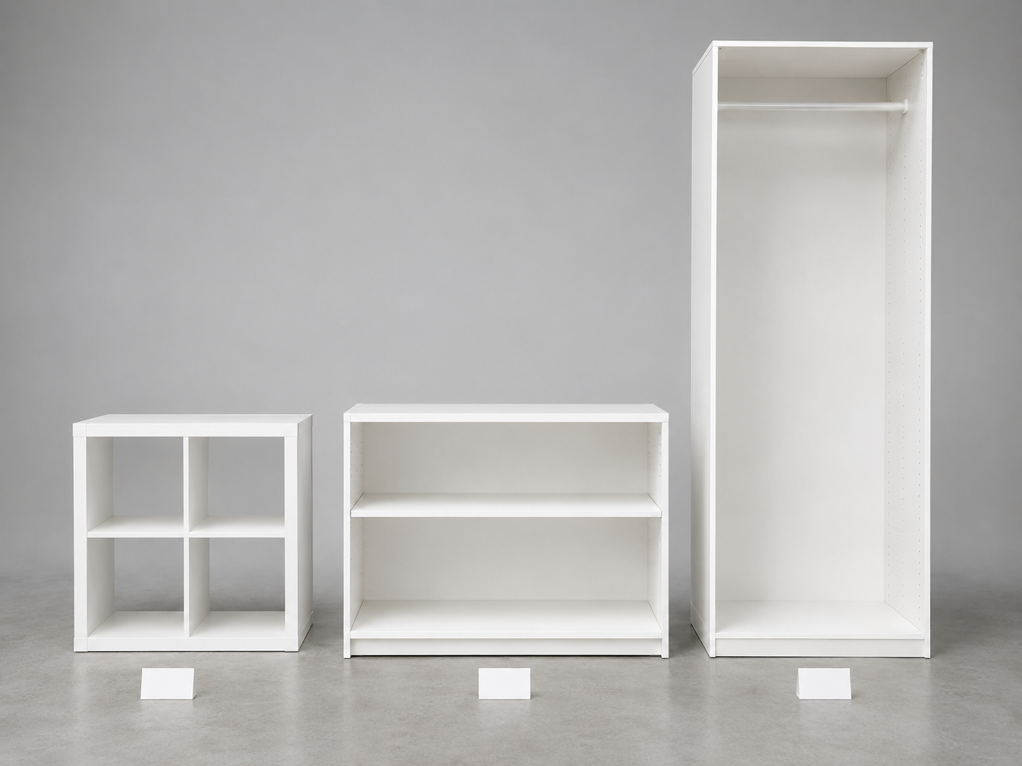 Три системы хранения IKEA: стеллаж KALLAX 2×2, каркас BESTÅ и гардероб PAX стоят рядом для сравнения нагрузки на полку